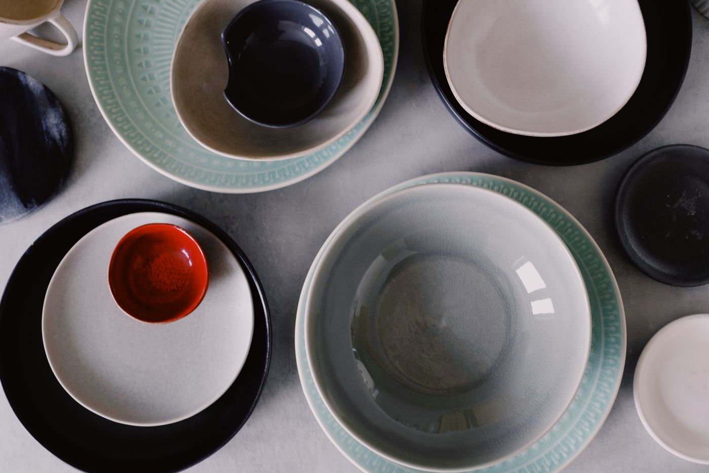 Illustrative coordinated ceramic plates and bowls arranged from above